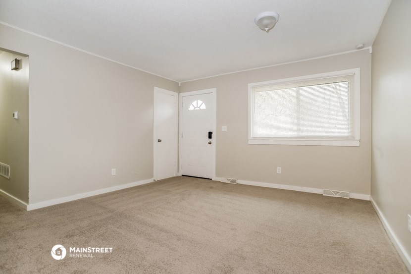 a bedroom with a carpeted floor and a door to a closet