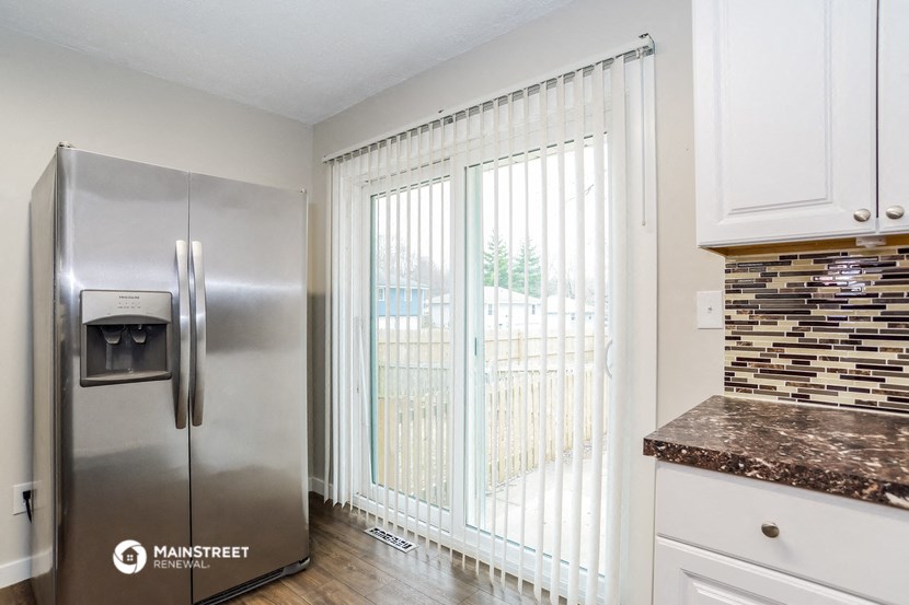 a kitchen with a stainless steel refrigerator and a sliding glass door