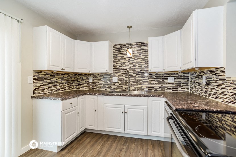 a kitchen with white cabinets and granite counter tops