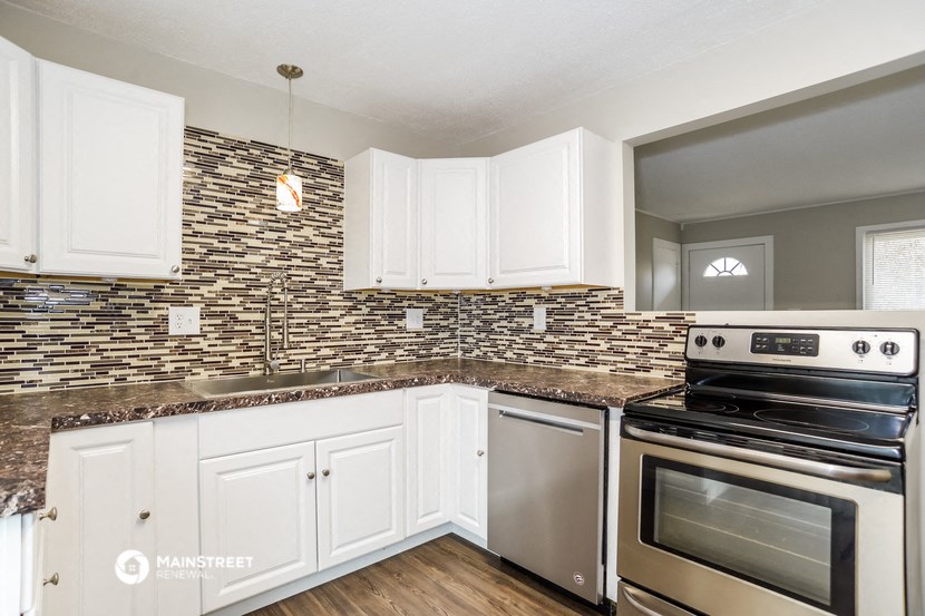 a kitchen with white cabinets and stainless steel appliances
