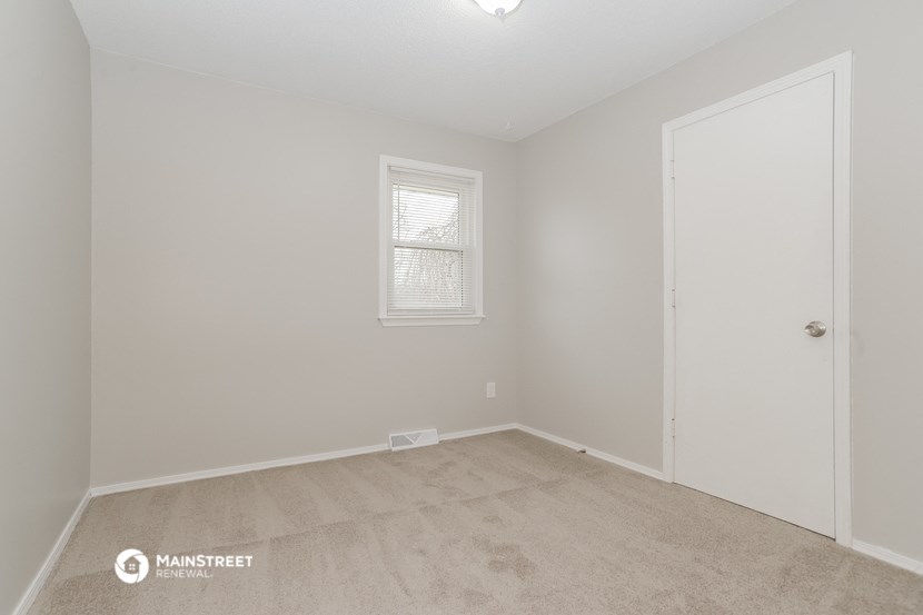 a bedroom with a carpeted floor and a white door