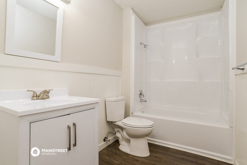a bathroom with a toilet and a sink and a shower