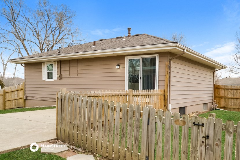 a tan house with a wooden fence in front of it