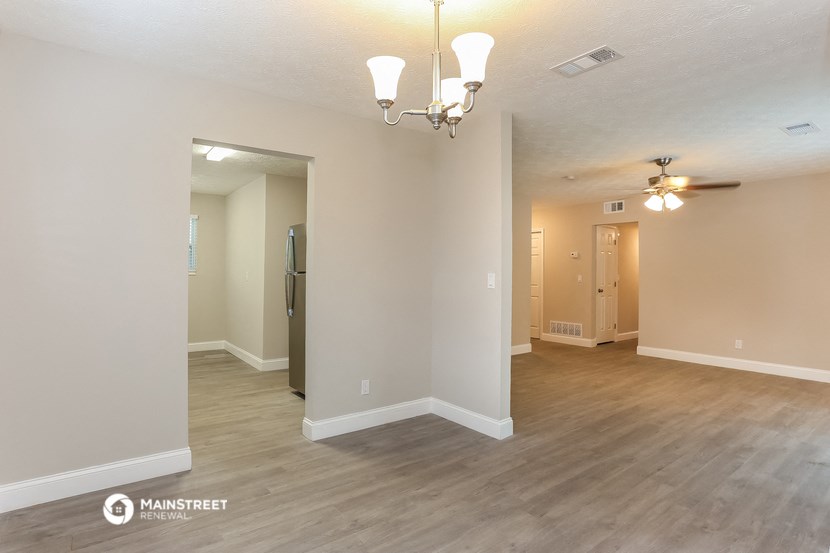 a living room and dining room with a wood floor and a ceiling fan