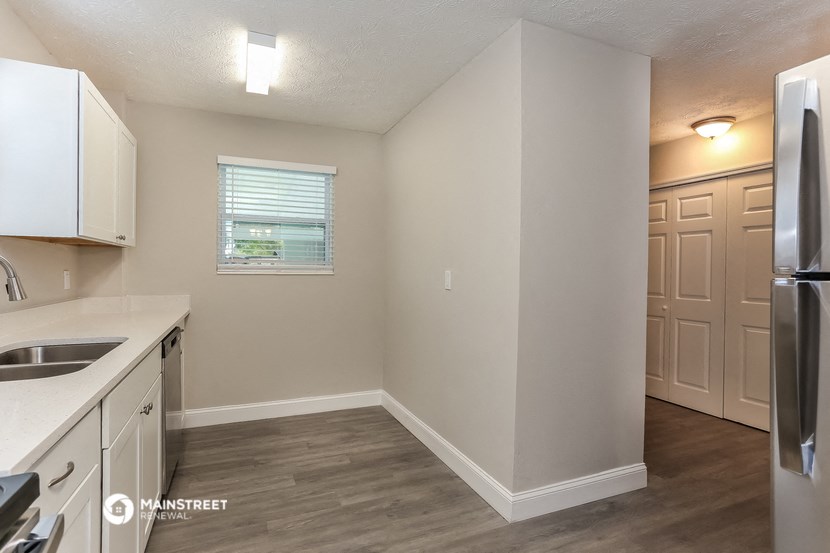 the kitchen of an apartment with white cabinets and stainless steel appliances