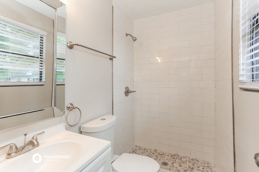 a white bathroom with a shower toilet and sink