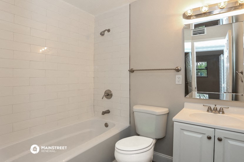 a white bathroom with a tub and a toilet and a sink