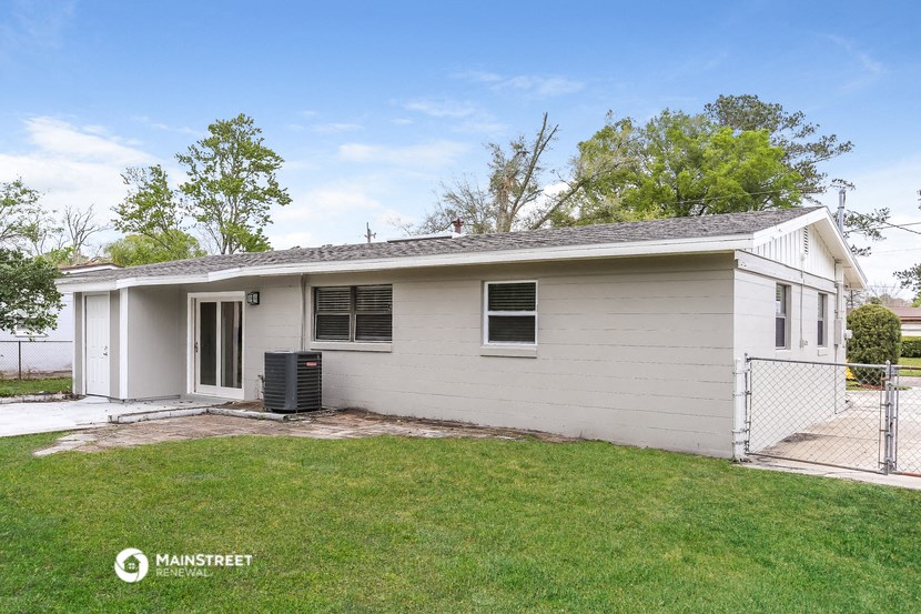 a small white house with a yard and a gate