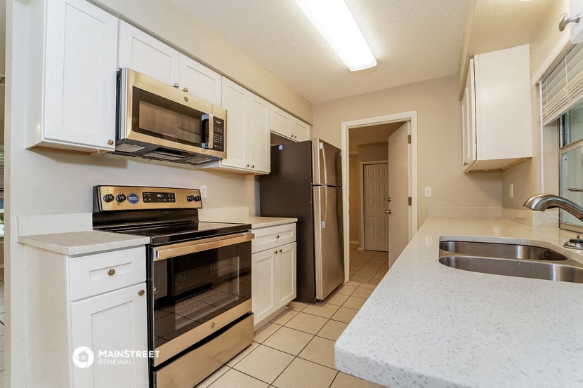a kitchen with stainless steel appliances and white cabinets