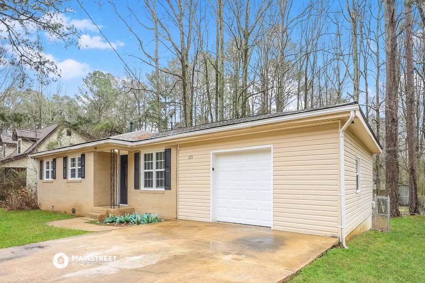 a small tan house with a white garage door