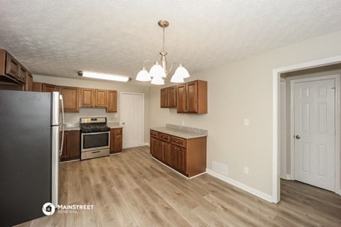 a kitchen with wood flooring and wooden cabinets and stainless steel appliances