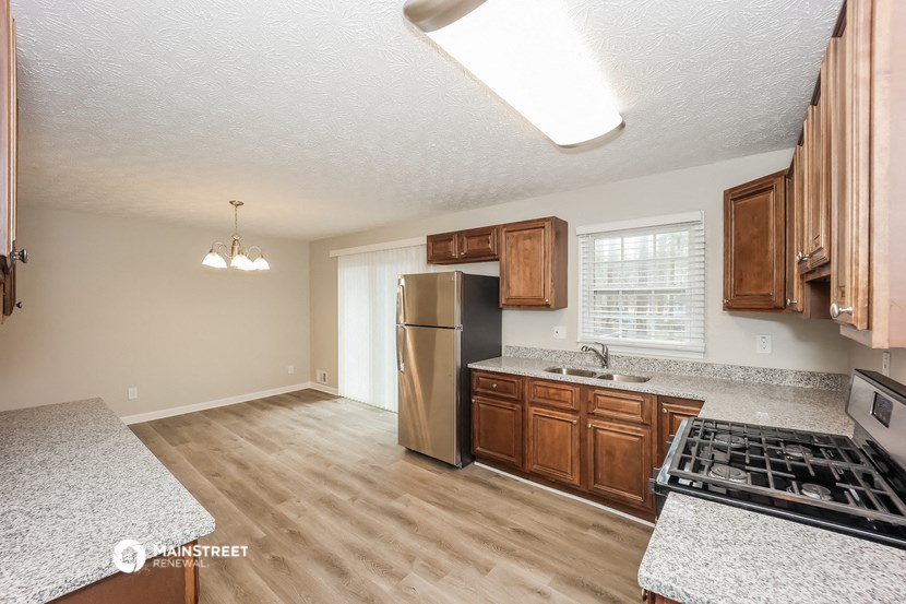 the kitchen is spacious and has stainless steel appliances and wood cabinets