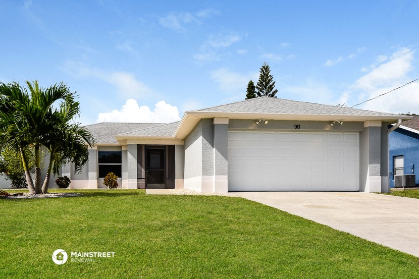 a white house with a lawn and a garage door