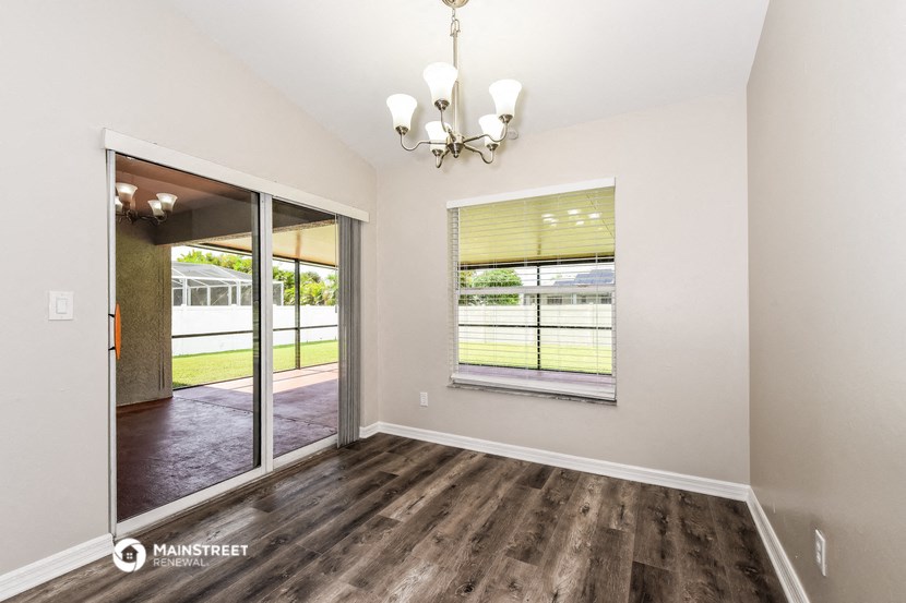 an empty living room with a window and a door to a yard