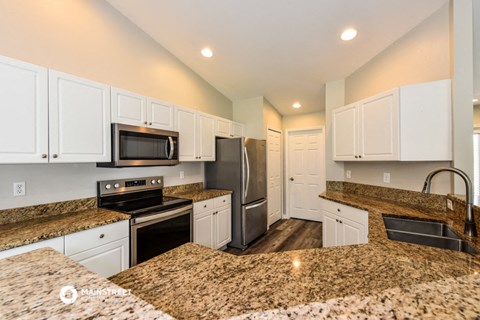 a kitchen with granite counter tops and stainless steel appliances