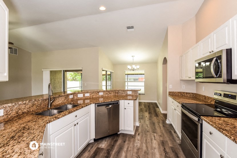 a kitchen with granite counter tops and white cabinets