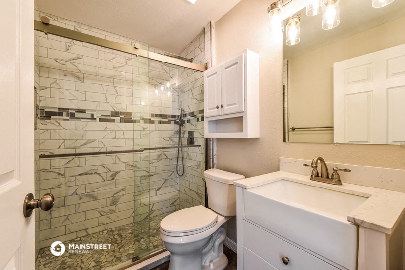 a bathroom with a shower toilet and sink