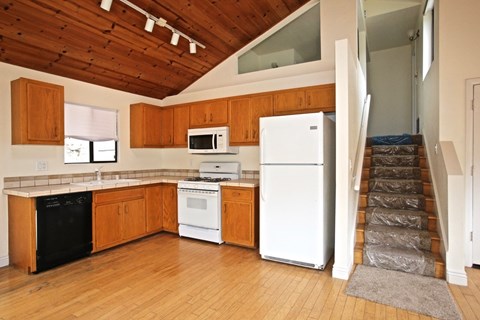 A kitchen with wooden cabinets and white appliances.