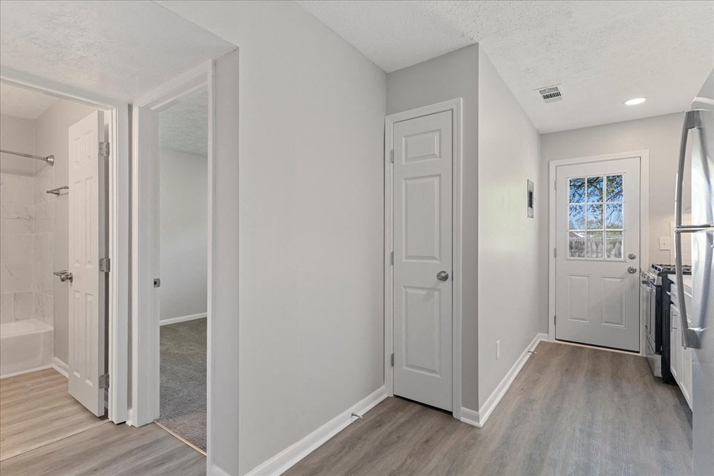 A bathroom with a white door and a window.