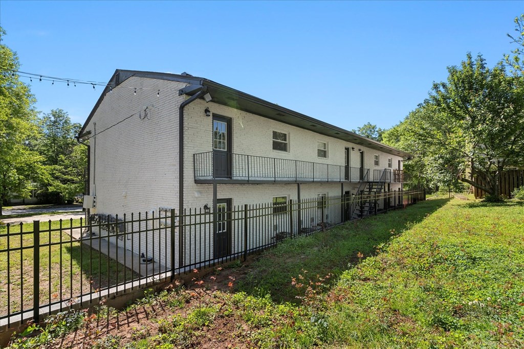 A white building with a black fence in front.