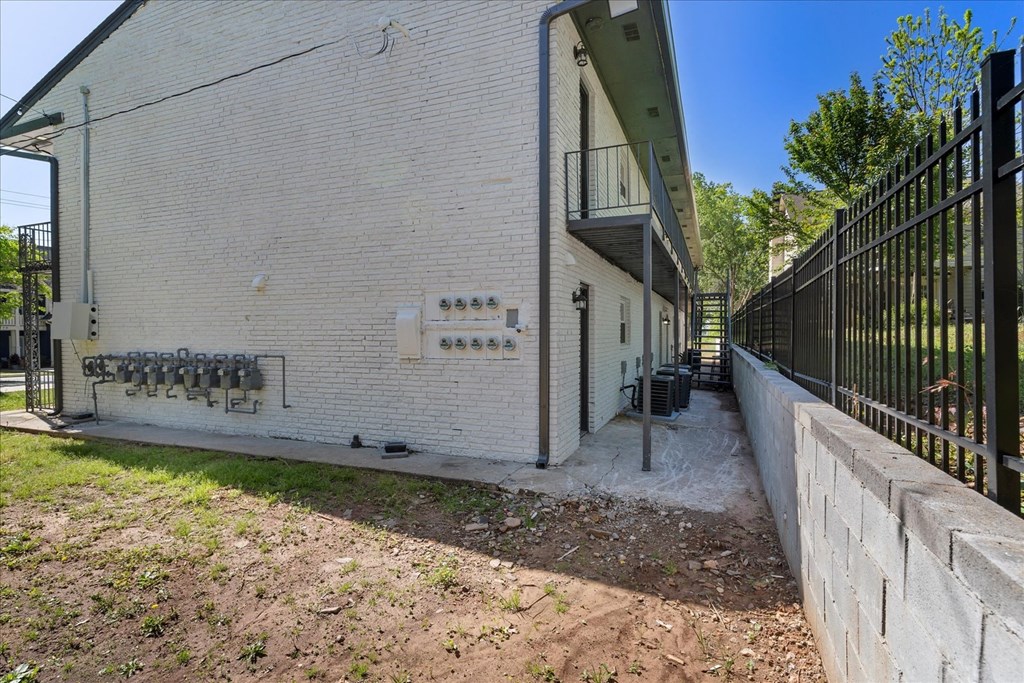 A white building with a black fence in front.
