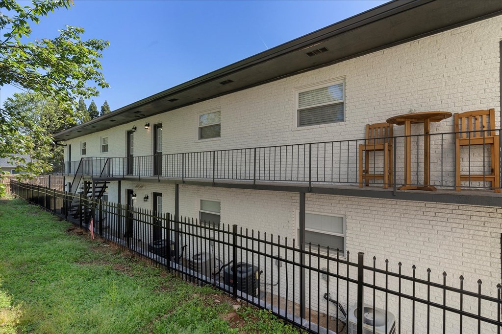 A white building with a black fence in front.