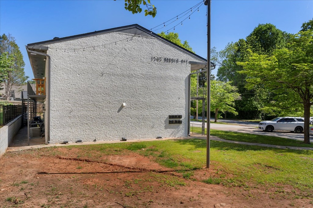 A white building with a black roof and a sign on it.