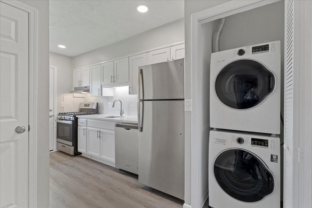 A modern kitchen with a washer and dryer stacked on top of each other.