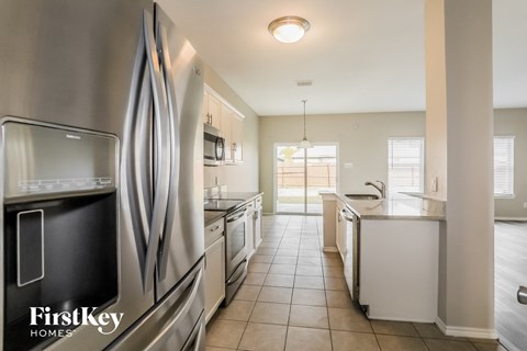 A kitchen with a stainless steel refrigerator and a white countertop.