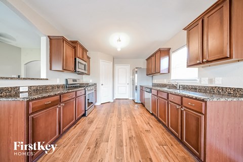 A kitchen with wooden cabinets and a granite countertop.