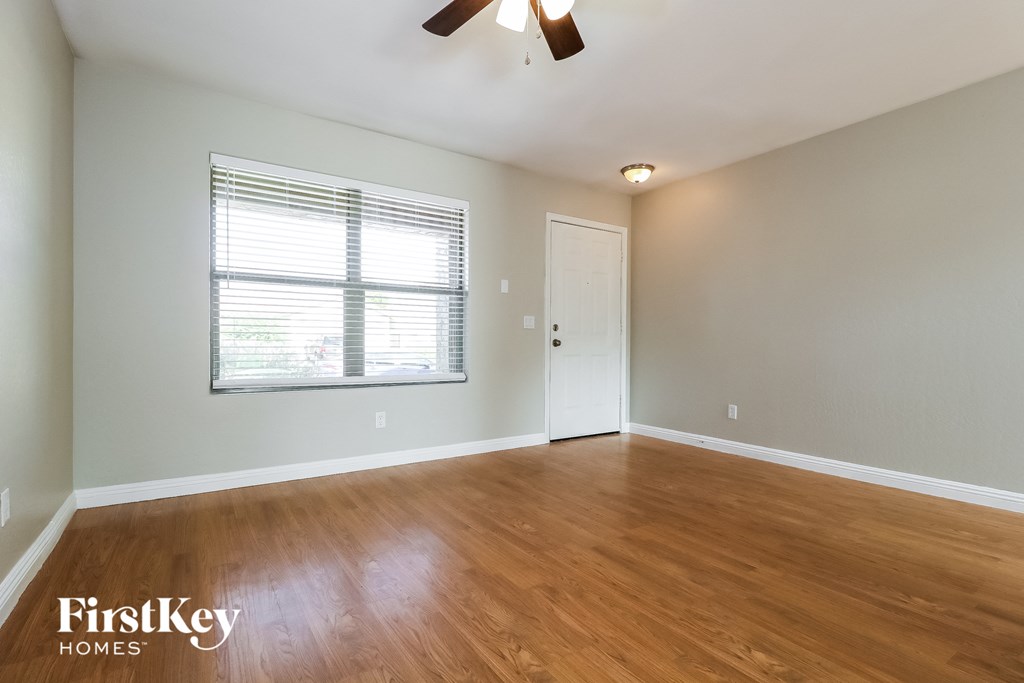 A room with wooden floors and a ceiling fan.