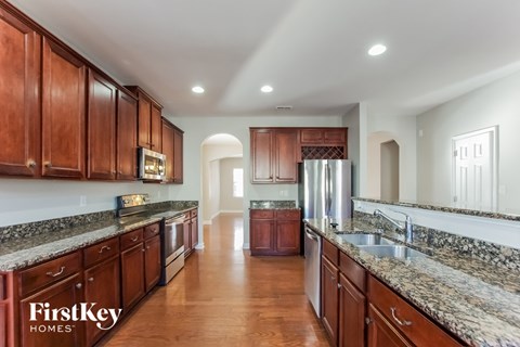 a large kitchen with granite counter tops and wooden cabinets and stainless steel appliances