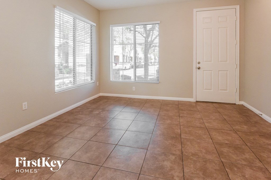 A room with tile flooring and a door is shown.