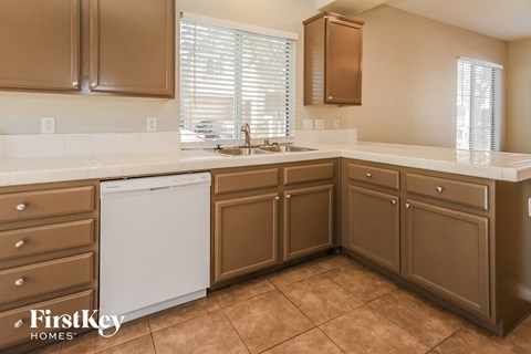 A kitchen with brown cabinets and a white dishwasher.