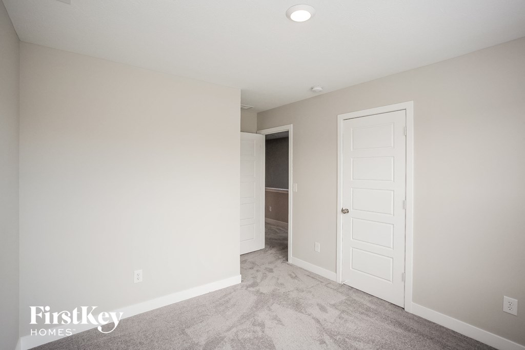 A room with a carpeted floor and a white door.
