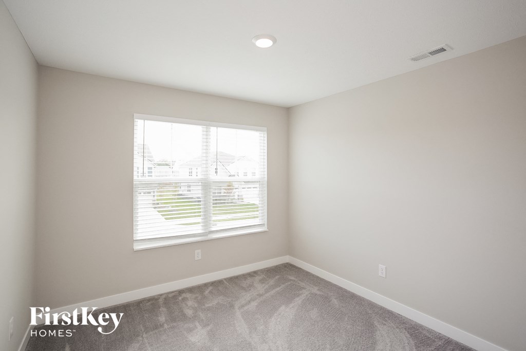 A room with a window and a view of a building outside.