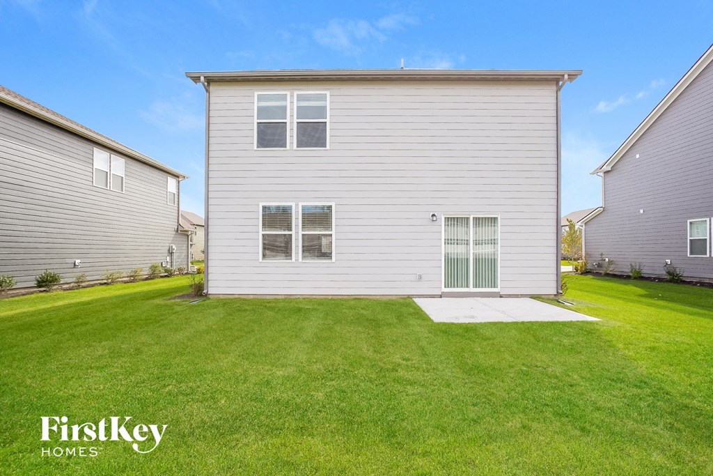 A grey house with a green lawn in front of it.