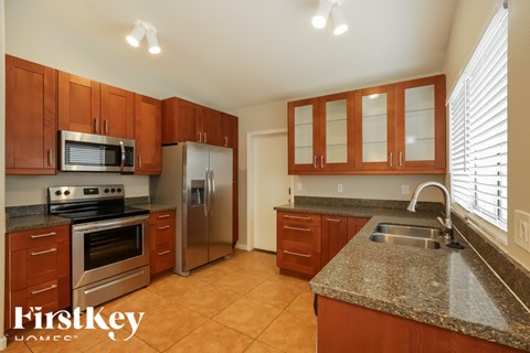 A kitchen with brown cabinets and a stainless steel refrigerator.