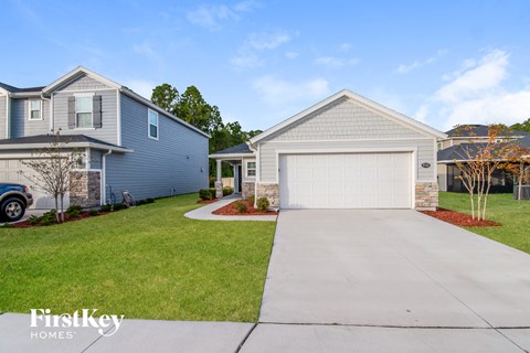 a blue house with a white garage door and a driveway