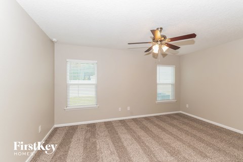 a bedroom with carpet and a ceiling fan
