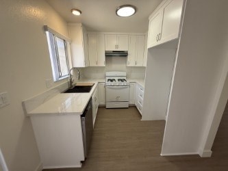 A white kitchen with a dishwasher and a stove top oven.