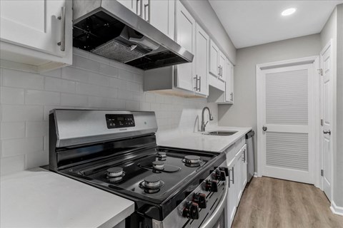 a kitchen with white cabinets and stainless steel appliances