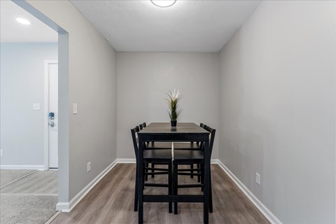 A dining room with a table and chairs.