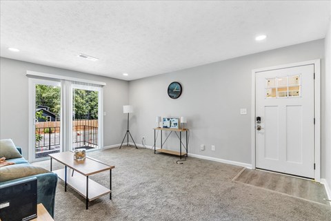 a living room with a couch and a door to a balcony