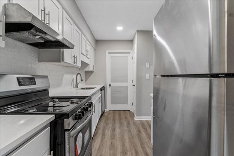 a kitchen with stainless steel appliances and white cabinets