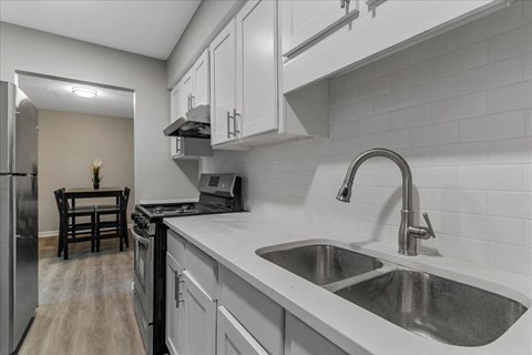 a kitchen with white cabinets and a sink