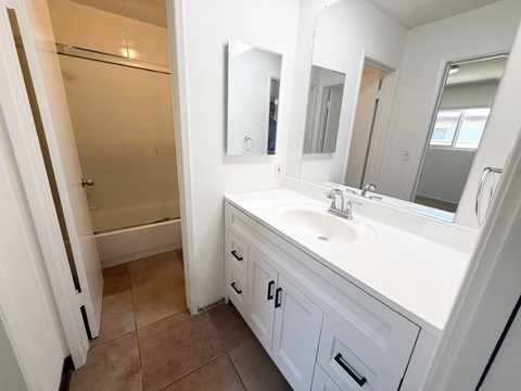 A bathroom with a white sink and a white vanity.