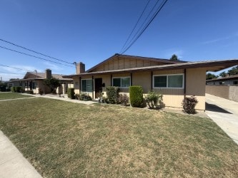 A house with a brown roof and a green bush in front.