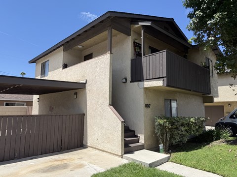 A two-story house with a balcony on the upper floor.