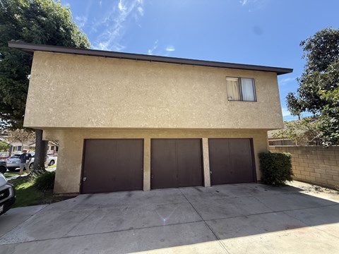 A house with a beige exterior and a brown garage door.